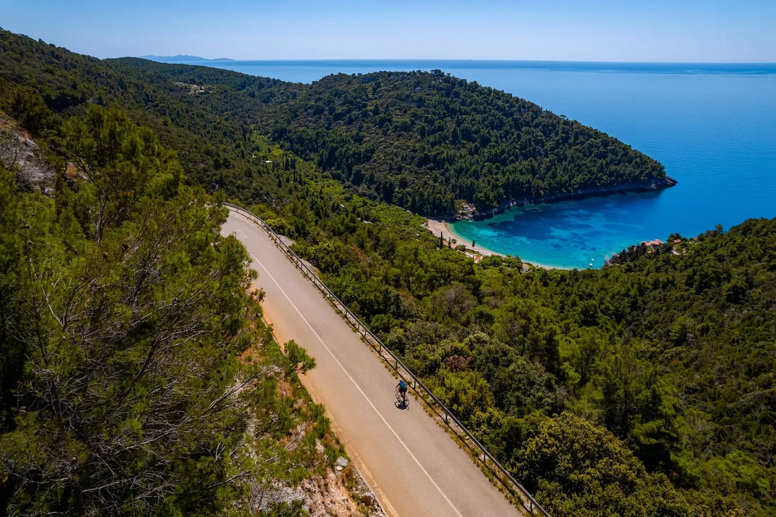 Cycling road above a turquoise bay on Korčula island